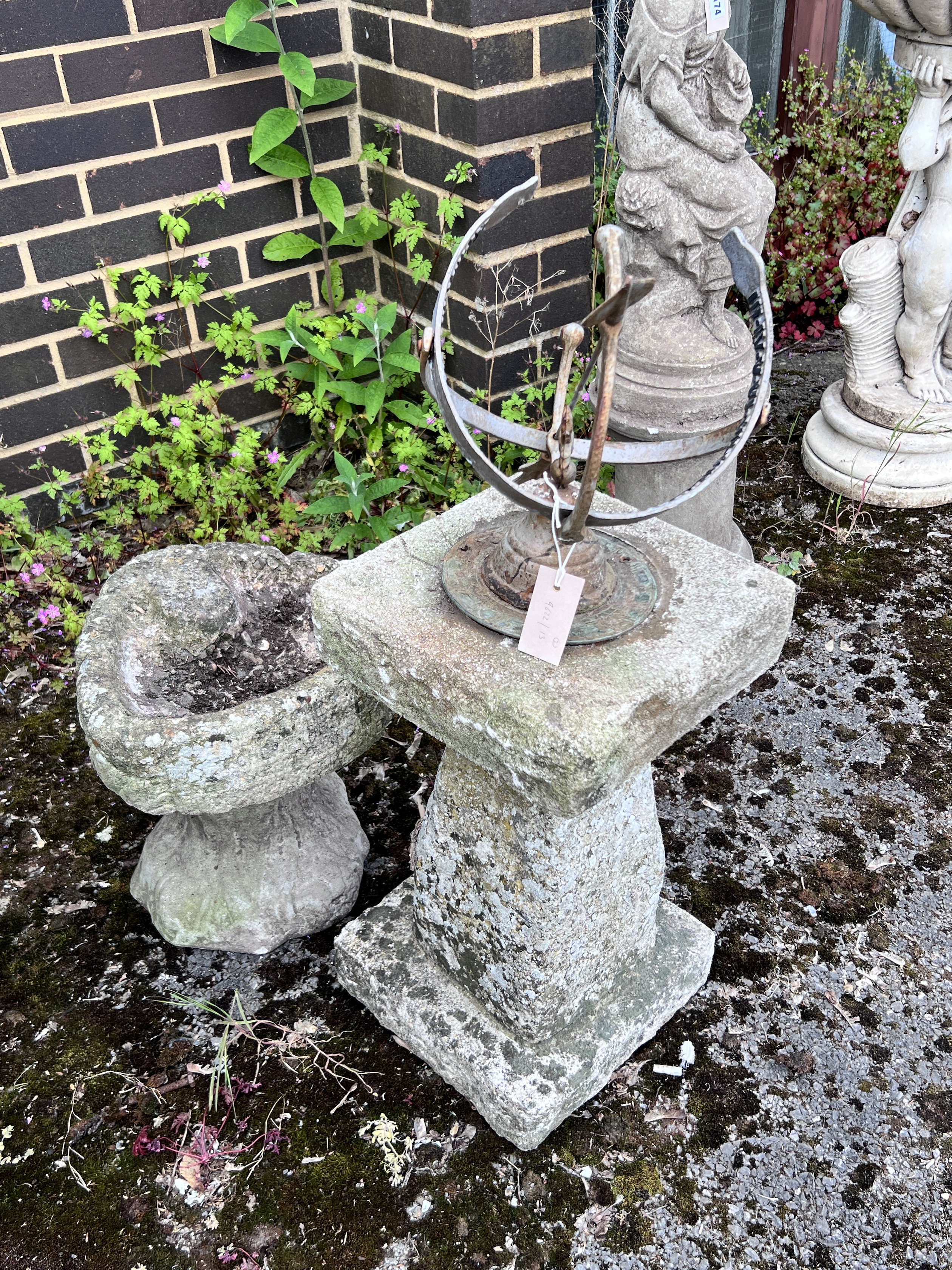 A sphere sundial on reconstituted stone plinth, height 85cm, and a smaller shell shaped bird bath